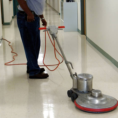 Commercial floor buffing machine in a hallway